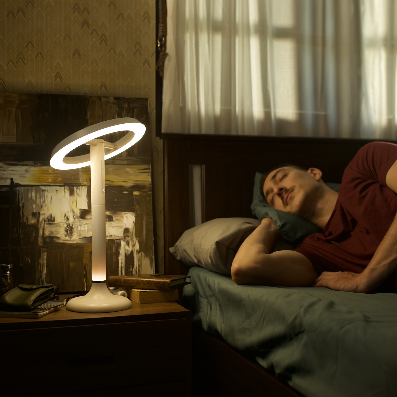 Sunflower X glowing softly on a bedside table next to a sleeping person